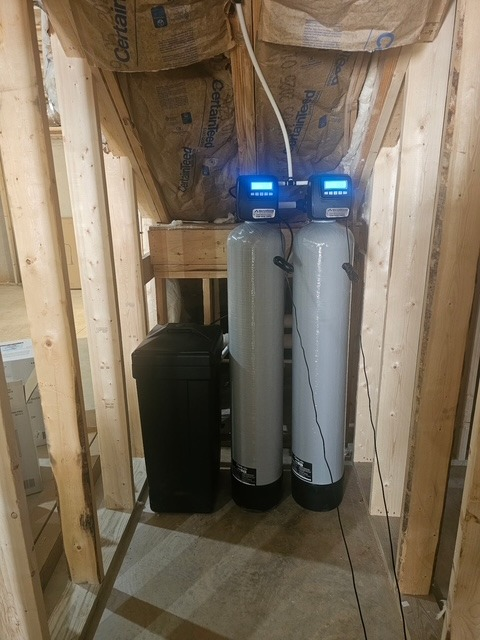 Twin softener tanks framed into a new-construction closet