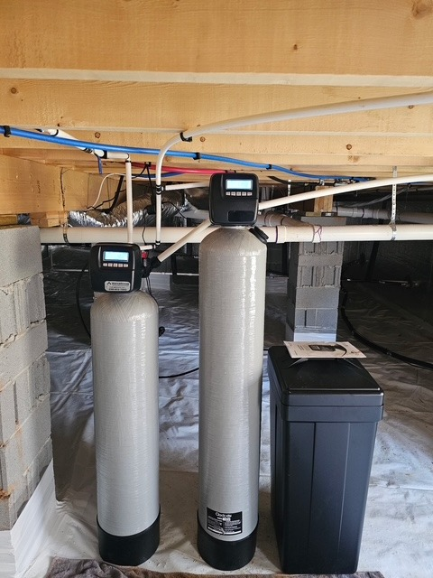 Twin fiberglass tanks plumbed through the floor joists